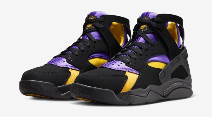 Side view of black, purple, and gold Nike Huarache shoes.